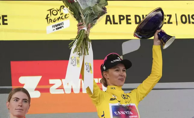 Tour de France winner Katarzyna Niewiadoma of Poland, wearing the overall leader's yellow jersey, celebrates next to second place Demi Vollering of The Netherlands, left, on the podium after the eighth stage of the Tour de France Women cycling race with start in Le Grand-Bornand and finish in Alpe d'Huez, France, Sunday, Aug. 18, 2024. (AP Photo/Peter Dejong)