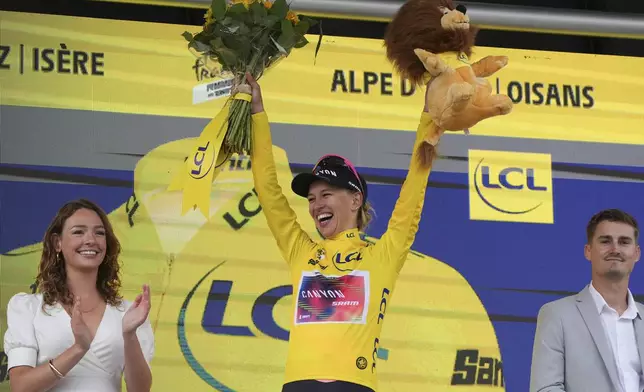 Tour de France Women's winner Katarzyna Niewiadoma of Poland, wearing the overall leader's yellow jersey, celebrates on the podium after the eighth stage of the Tour de France Women cycling race with start in Le Grand-Bornand and finish in Alpe d'Huez, France, Sunday, Aug. 18, 2024. (AP Photo/Peter Dejong)