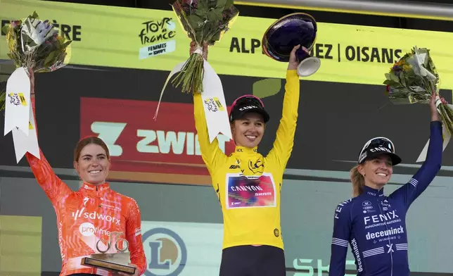 Tour de France Women winner Katarzyna Niewiadoma of Poland, wearing the overall leader's yellow jersey, Demi Vollering of The Netherlands, left and second place, and Pauliena Rooijakkers of The Netherlands, right and third place, celebrate on the podium after the eighth stage of the Tour de France Women cycling race with start in Le Grand-Bornand and finish in Alpe d'Huez, France, Sunday, Aug. 18, 2024. (AP Photo/Peter Dejong)