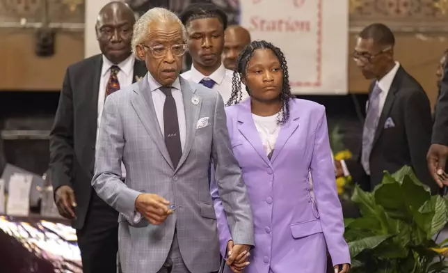 Rev. Al Sharpton, left, holds hands and leads Summer Massey, daughter of Sonya Massey, to the podium during a press conference over the shooting death of Sonya, who was killed by Illinois sheriff's deputy Sean Grayson, at New Mount Pilgrim Church in the Garfield Park neighborhood in Chicago, Tuesday, July 30, 2024. (Tyler Pasciak LaRiviere/Chicago Sun-Times via AP)