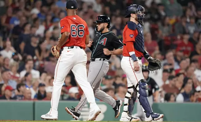 Arizona Diamondbacks' Adrian Del Castillo, center, scores near starting pitcher Brayan Bello (66) and catcher Danny Jansen, right, on a double by Luis Guillorme during the sixth inning of a baseball game, Friday, Aug. 23, 2024, in Boston. (AP Photo/Michael Dwyer)