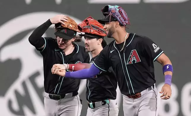 From left to right, Arizona Diamondbacks outfielders Jake McCarthy, Corbin Carroll and Lourdes Gurriel Jr. celebrate after defeating the Boston Red Sox in a baseball game, Friday, Aug. 23, 2024, in Boston. (AP Photo/Michael Dwyer)