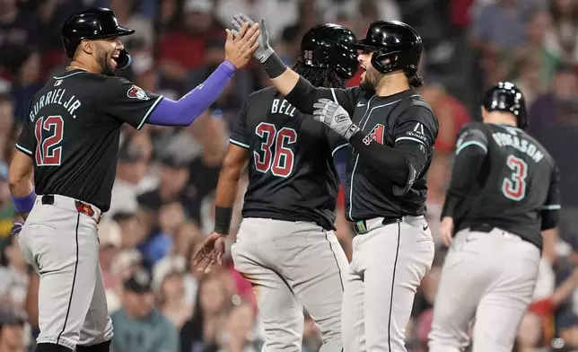 Arizona Diamondbacks' Eugenio Suárez, third from left, celebrates after his grand slam that also drove in Lourdes Gurriel Jr. (12), Josh Bell (36) and Joc Pederson (3) during the seventh inning of a baseball game against the Boston Red Sox, Friday, Aug. 23, 2024, in Boston. (AP Photo/Michael Dwyer)