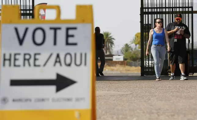 Voters walk to a voting station to cast their votes Tuesday, July 30, 2024, in Guadalupe, Ariz. (AP Photo/Ross D. Franklin)