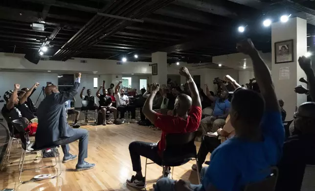 Panelists and attendees raise their fists during a Black Man Lab meeting to discuss the candidacy of Vice President Kamala Harris, Monday, July 22, 2024, in Atlanta. (AP Photo/Stephanie Scarbrough)