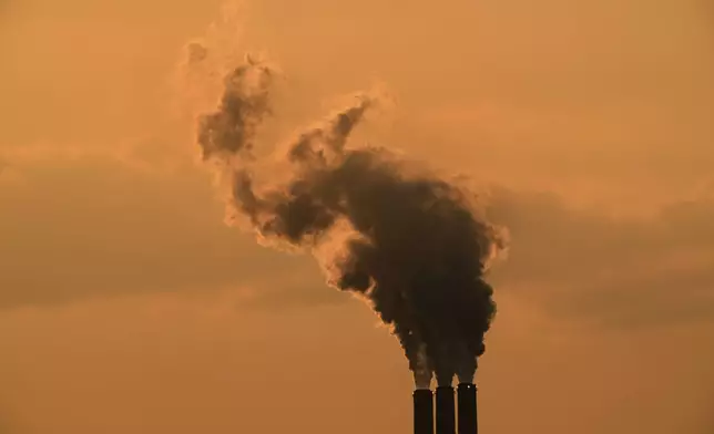 FILE - Smokestacks at the Jeffrey Energy Center coal-fired power plant are silhouetted against the sky at sunset Sept. 12, 2020, near Emmet, Kan. (AP Photo/Charlie Riedel, File)