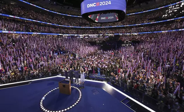 Democratic vice presidential nominee Minnesota Gov. Tim Walz is joined on stage by his wife Gwen, and children Gus and Hope, on the third day of the Democratic National Convention in Chicago, Wednesday, Aug. 21, 2024. (Mike Segar/Pool via AP)