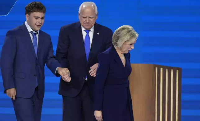 Democratic vice presidential nominee Minnesota Gov. Tim Walz, center, walks off stage with his wife Gwen Walz, right, and son Gus Walz after speaking during the Democratic National Convention Wednesday, Aug. 21, 2024, in Chicago. (AP Photo/J. Scott Applewhite)