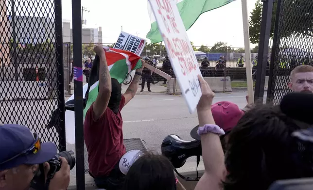 Protesters knock down a fence at the Democratic National Convention at the United Center after a rally at Union Park Monday, Aug. 19, 2024, in Chicago. (AP Photo/Alex Brandon)