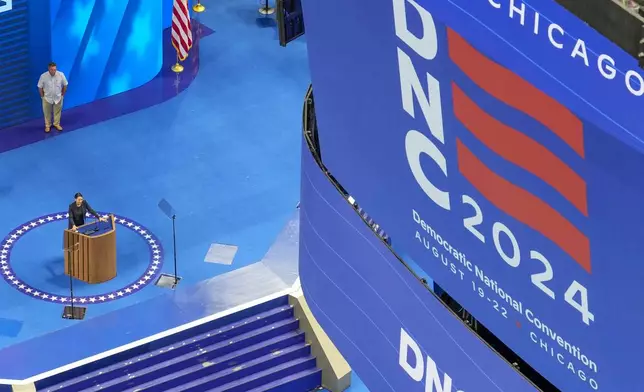 Rep. Alexandria Ocasio-Cortez, D-NY, stands at the podium at the Democratic National Convention at the United Center Saturday, Aug. 17, 2024, in Chicago. (AP Photo/Morry Gash)