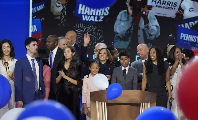 Democratic presidential nominee Vice President Kamala Harris, center, hugs her grand-niece Amara Ajagu surrounded by family during the Democratic National Convention Thursday, Aug. 22, 2024, in Chicago. (AP Photo/J. Scott Applewhite)