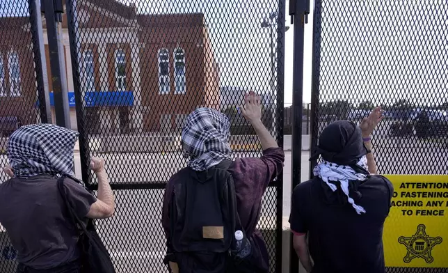 Protesters are stopped by a fence during a march to the Democratic National Convention Monday, Aug. 19, 2024, in Chicago. (AP Photo/Alex Brandon)