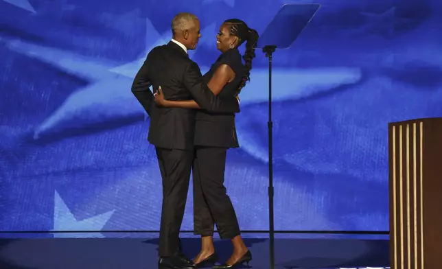 Former President Barack Obama, left, hugs former first lady Michelle Obama before speaking during Democratic National Convention in Chicago on Tuesday, Aug. 20, 2024. (Gabrielle Lurie/San Francisco Chronicle via AP)