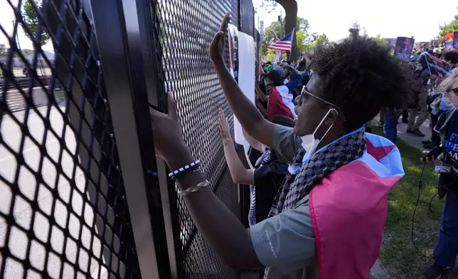 Protesters are stopped by a fence during a march to the Democratic National Convention Monday, Aug. 19, 2024, in Chicago. (AP Photo/Alex Brandon)