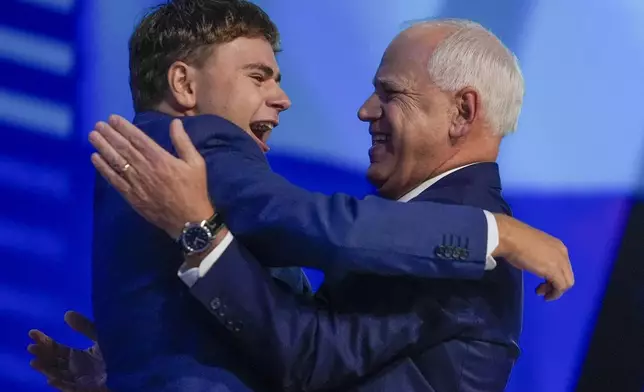 Democratic vice presidential nominee Minnesota Gov. Tim Walz hugs his son Gus during the Democratic National Convention Wednesday, Aug. 21, 2024, in Chicago. (AP Photo/Erin Hooley)