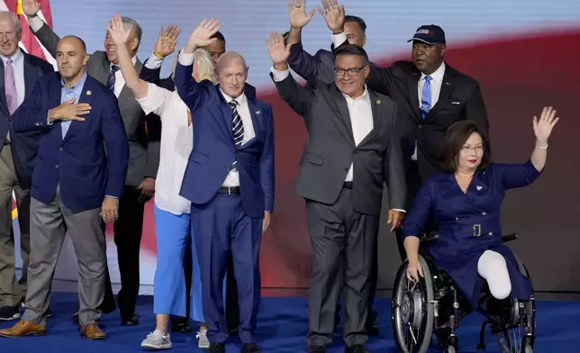 Democratic veterans serving in local, state and federal levels of government stand alongside Rep. Ruben Gallego, D-Ariz., during the Democratic National Convention Thursday, Aug. 22, 2024, in Chicago. (AP Photo/J. Scott Applewhite)