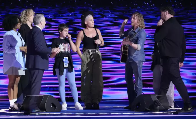 Pink, fifth from left, stands on stage during a sound check before the start of night four of the Democratic National Convention Thursday, Aug. 22, 2024, in Chicago. (AP Photo/J. Scott Applewhite)