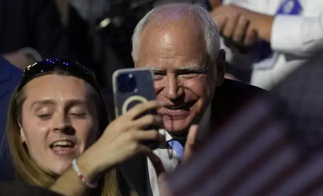 Democratic vice presidential nominee Minnesota Gov. Tim Walz has a picture taken during the Democratic National Convention Thursday, Aug. 22, 2024, in Chicago. (AP Photo/Matt Rourke)