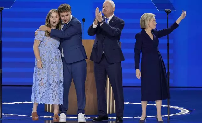 Democratic vice presidential nominee Minnesota Gov. Tim Walz, second from right, poses with his wife Gwen Walz, from right, son Gus Walz and daughter Hope Walz after speaking during the Democratic National Convention Wednesday, Aug. 21, 2024, in Chicago. (AP Photo/J. Scott Applewhite)