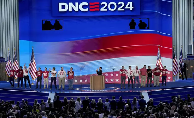 Benjamin C. Ingman, center, former student of Democratic vice presidential candidate Minnesota Gov. Tim Walz, is joined on stage by former members of the Mankato West High School football team during the Democratic National Convention Wednesday, Aug. 21, 2024, in Chicago. (AP Photo/J. Scott Applewhite)