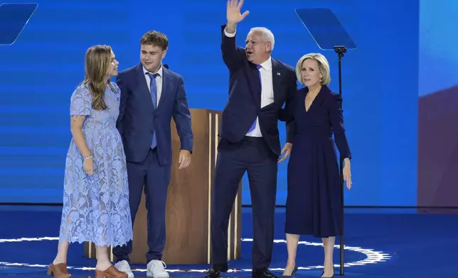 Democratic vice presidential nominee Minnesota Gov. Tim Walz, second from right, poses with his wife Gwen Walz, from right, son Gus Walz and daughter Hope Walz after speaking during the Democratic National Convention Wednesday, Aug. 21, 2024, in Chicago. (AP Photo/J. Scott Applewhite)