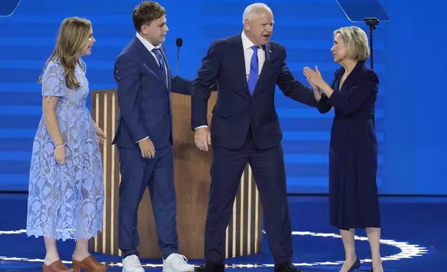 Democratic vice presidential nominee Minnesota Gov. Tim Walz, second from right, appears on stage with his wife Gwen Walz, from right, son Gus Walz and daughter Hope Walz after speaking during the Democratic National Convention Wednesday, Aug. 21, 2024, in Chicago. (AP Photo/J. Scott Applewhite)