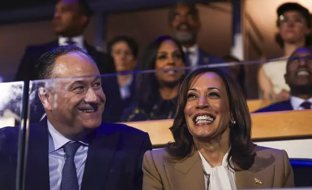 Second gentleman Doug Emhoff, left, and Democratic presidential nominee Vice President Kamala Harris listen during speeches at the Democratic National Convention, Monday, Aug. 19, 2024, in Chicago. (Gabrielle Lurie/San Francisco Chronicle via AP)