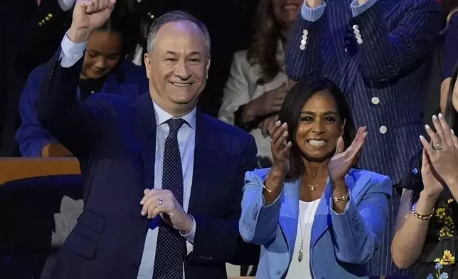 Second Gentalman Douglas Emhoff and Maya Harris clap during the Democratic National Convention Wednesday, Aug. 21, 2024, in Chicago. (AP Photo/Charles Rex Arbogast)