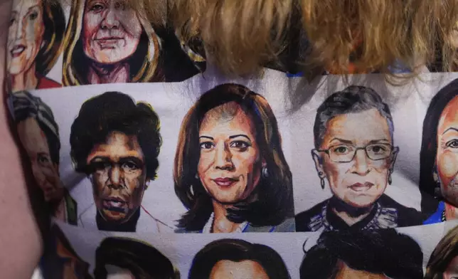 A person wears a printed shirt with many portraits, including Democratic presidential nominee Vice President Kamala Harris, during the Democratic National Convention Wednesday, Aug. 21, 2024, in Chicago. (AP Photo/Erin Hooley)