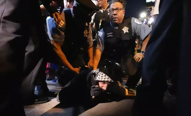 A demonstrators is taken into custody by police police near the Israeli Consulate during the Democratic National Convention Tuesday, Aug. 20, 2024, in Chicago. (AP Photo/Alex Brandon)