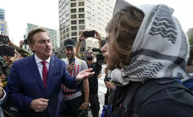 Election denier Mike Lindell of MyPillow and a demonstrator argue near the Israeli Consulate during the Democratic National Convention Tuesday, Aug. 20, 2024, in Chicago. (AP Photo/Julio Cortez)