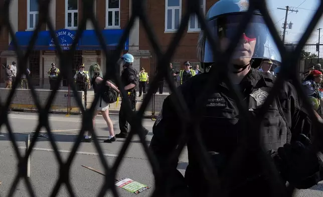 Police take a protester into custody after a fence surrounding United Center was knock down at the Democratic National Convention Monday, Aug. 19, 2024, in Chicago. (AP Photo/Frank Franklin II)