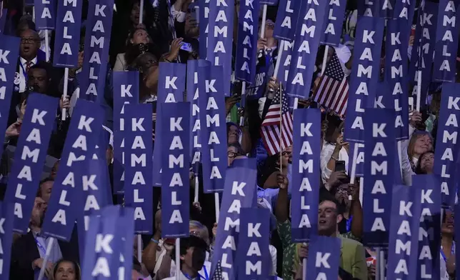 Delegates hold signs as Democratic presidential nominee Vice President Kamala Harris speaks during the Democratic National Convention Thursday, Aug. 22, 2024, in Chicago. (AP Photo/Brynn Anderson)