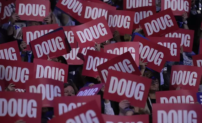 Delegates hold up signs as Second gentleman Douglas Emhoff speaks during the Democratic National Convention Tuesday, Aug. 20, 2024, in Chicago. (AP Photo/Brynn Anderson)