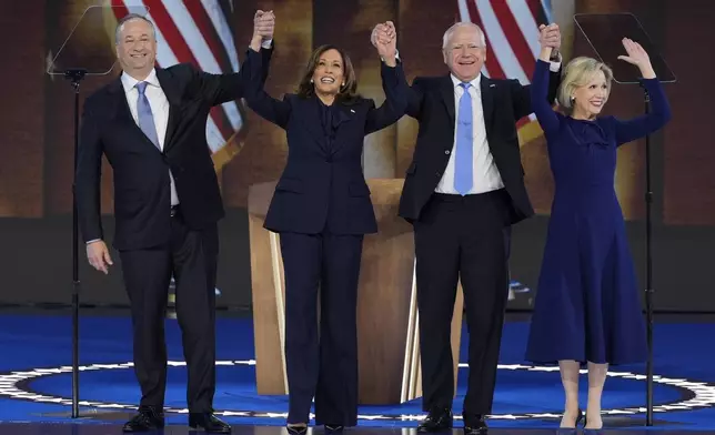 Second gentleman Doug Emhoff, from left, Democratic presidential nominee Vice President Kamala Harris, her running mate Minnesota Gov. Tim Walz and his wife Gwen Walz wave at the Democratic National Convention Thursday, Aug. 22, 2024, in Chicago. (AP Photo/J. Scott Applewhite)