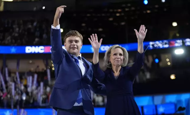 Democratic vice presidential nominee Minnesota Gov. Tim Walz's son Gus and wife Gwen react during the Democratic National Convention Wednesday, Aug. 21, 2024, in Chicago. (AP Photo/Paul Sancya)