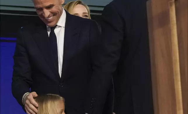 Grandson Beau Biden holds President Joe Biden's hands as Hunter Biden smiles during the first day of Democratic National Convention, Monday, Aug. 19, 2024, in Chicago. (AP Photo/Jacquelyn Martin)