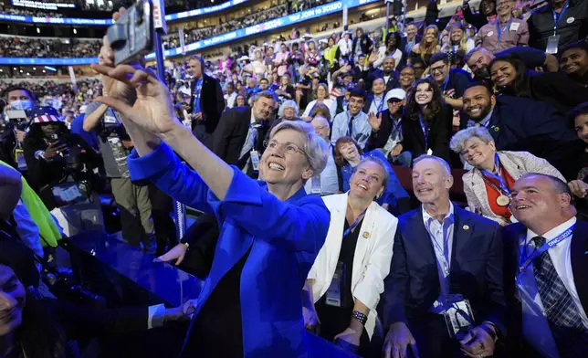 Sen. Elizabeth Warren, D-Mass., takes a selfie with Massachusetts delegates during the Democratic National Convention Wednesday, Aug. 21, 2024, in Chicago. (AP Photo/Paul Sancya)