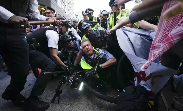 Demonstrators clash with police near the Israeli Consulate during the Democratic National Convention Tuesday, Aug. 20, 2024, in Chicago. (AP Photo/Julio Cortez)