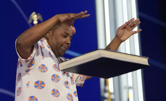 Kenan Thompson drops a copy of Project 2025 onto the table during the Democratic National Convention Wednesday, Aug. 21, 2024, in Chicago. (AP Photo/Paul Sancya)