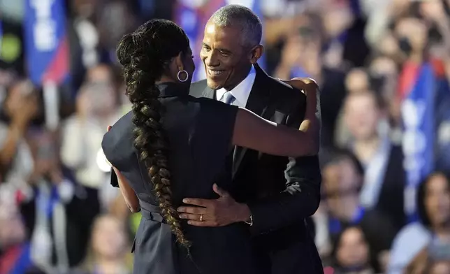 Former President Barack Obama hugs his wife Former First Lady Michelle Obama during the Democratic National Convention Tuesday, Aug. 20, 2024, in Chicago. (AP Photo/Charles Rex Arbogast)