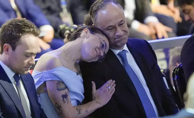 Second gentleman Doug Emhoff and daughter Ella listen during the Democratic National Convention Thursday, Aug. 22, 2024, in Chicago. (AP Photo/Charles Rex Arbogast)