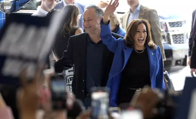 Democratic presidential nominee Vice President Kamala Harris, right, and second gentleman Doug Emhoff greet supporters upon arriving at Pittsburgh International Airport, Sunday, Aug. 18, 2024, in Pittsburgh. (AP Photo/Julia Nikhinson)