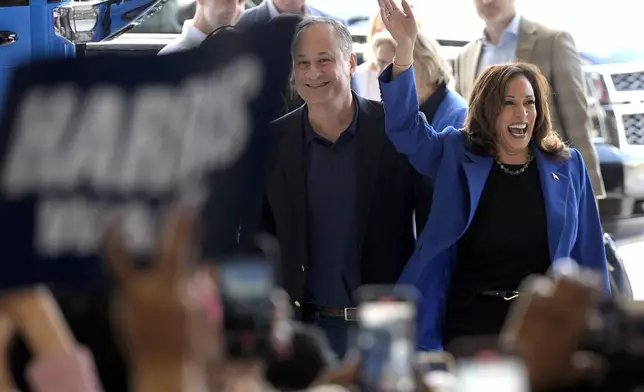 Democratic presidential nominee Vice President Kamala Harris, right, and second gentleman Doug Emhoff greet supporters upon arriving at Pittsburgh International Airport, Sunday, Aug. 18, 2024, in Pittsburgh. (AP Photo/Julia Nikhinson)