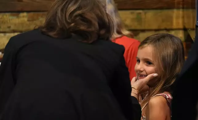 Democratic presidential nominee Vice President Kamala Harris talks to a young child as she visits SandFly Bar-B-Q in Savannah, Ga., Wednesday, Aug. 28, 2024. (AP Photo/Jacquelyn Martin)