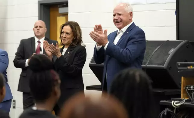 Democratic presidential nominee Vice President Kamala Harris and Democratic vice presidential candidate Minnesota Gov. Tim Walz speak to marching band members at Liberty County High School in Hinesville, Ga., Wednesday, Aug. 28, 2024. (AP Photo/Jacquelyn Martin)