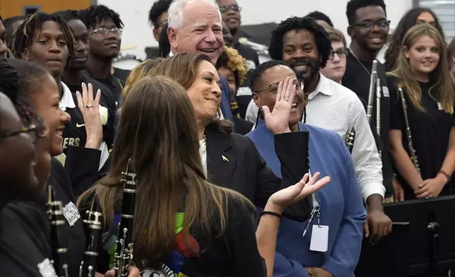 Democratic presidential nominee Vice President Kamala Harris and Democratic vice presidential candidate Minnesota Gov. Tim Walz poses for a photo with marching band members at Liberty County High School in Hinesville, Ga., Wednesday, Aug. 28, 2024. (AP Photo/Jacquelyn Martin)