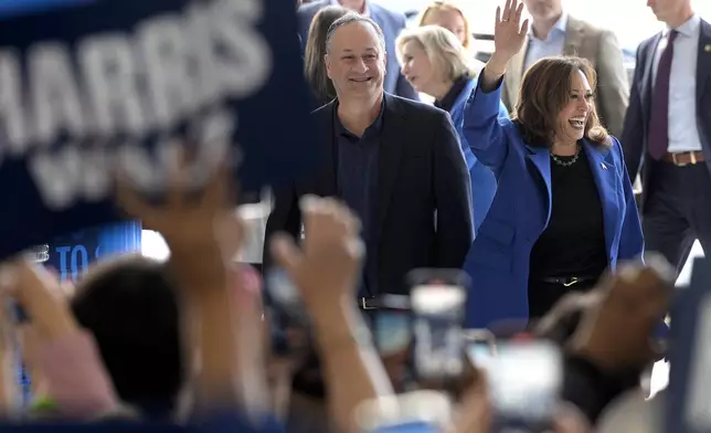 Democratic presidential nominee Vice President Kamala Harris, right, and second gentleman Doug Emhoff greet supporters upon arriving at Pittsburgh International Airport, Sunday, Aug. 18, 2024, in Pittsburgh. (AP Photo/Julia Nikhinson)