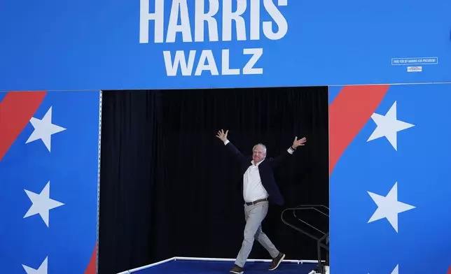 Democratic vice presidential candidate Minnesota Gov. Tim Walz arrives to speak at a campaign rally Wednesday, Aug. 7, 2024, in Romulus, Mich., before Democratic presidential nominee Vice President Kamala Harris. (AP Photo/Julia Nikhinson)