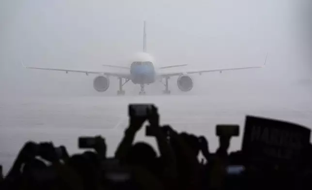 Supports look on as Air Force Two with Democratic presidential nominee Vice President Kamala Harris on board lands at Pittsburgh International Airport, Sunday, Aug. 18, 2024, in Pittsburgh, (AP Photo/Julia Nikhinson)